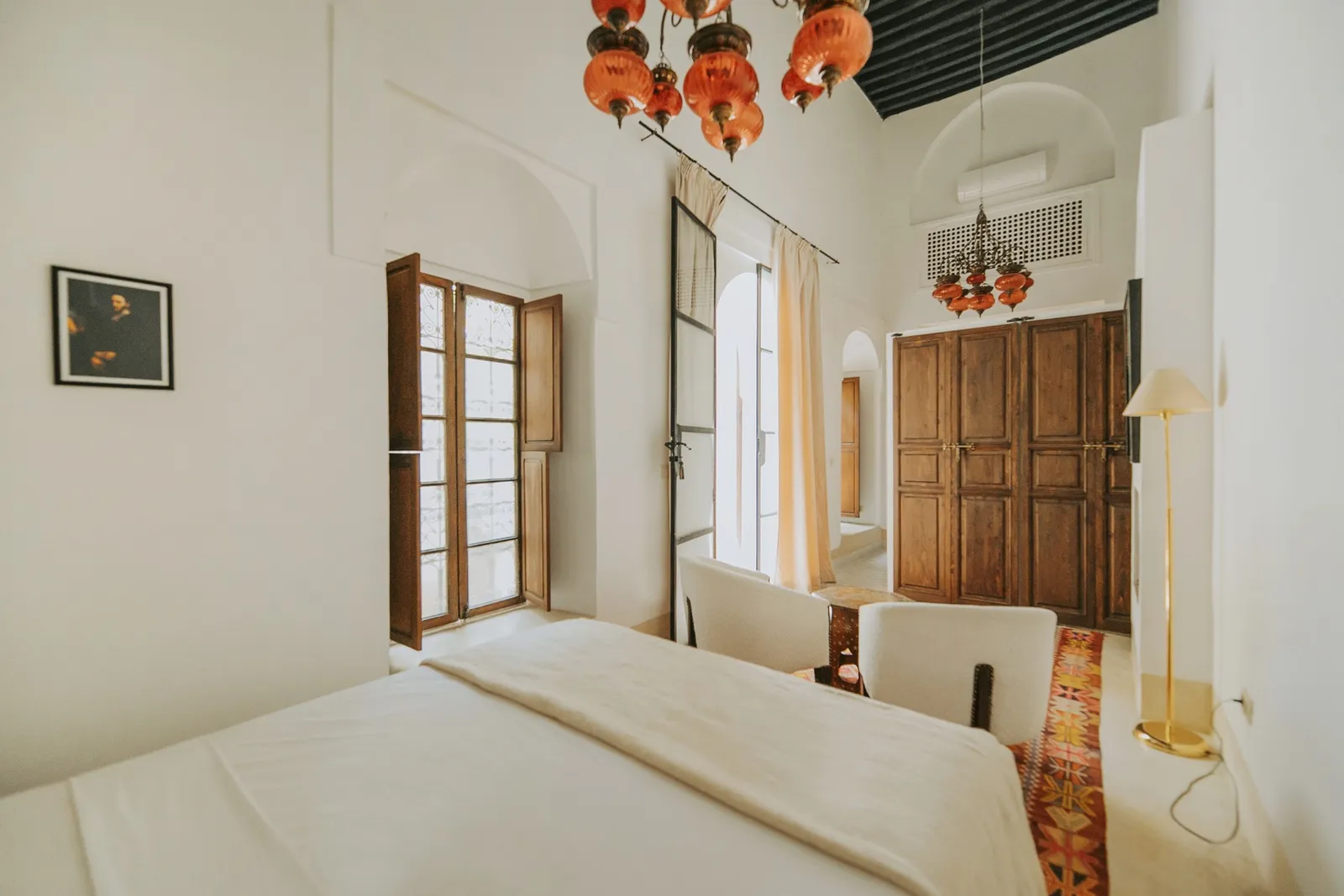Vue d’ensemble de la chambre, du lit au coin salon