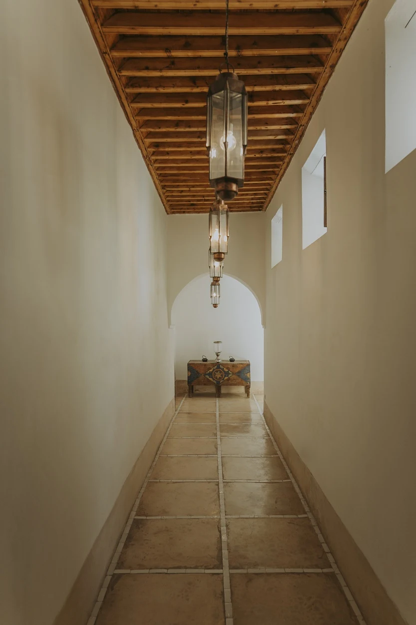 Longue coursive blanche coiffée d’un plafond en bois