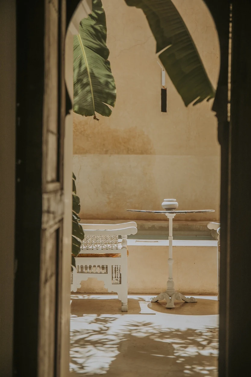 Table blanche aperçue depuis une porte sombre du patio