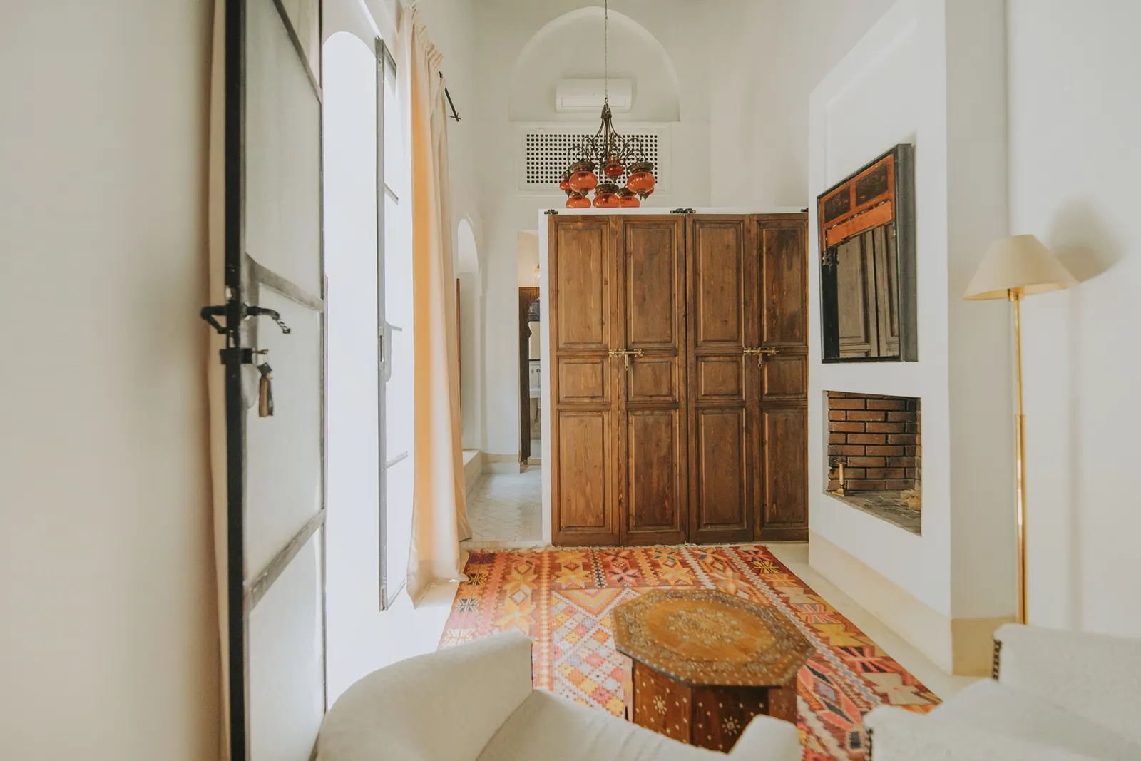 Coin salon avec tapis géométrique, boiseries et niche-cheminée